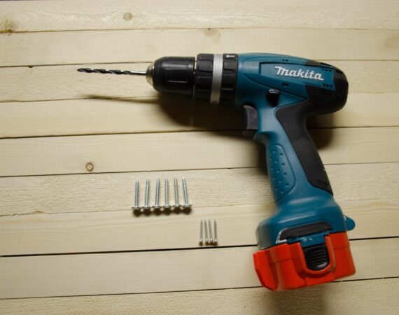 Drill and drill bits on wood background