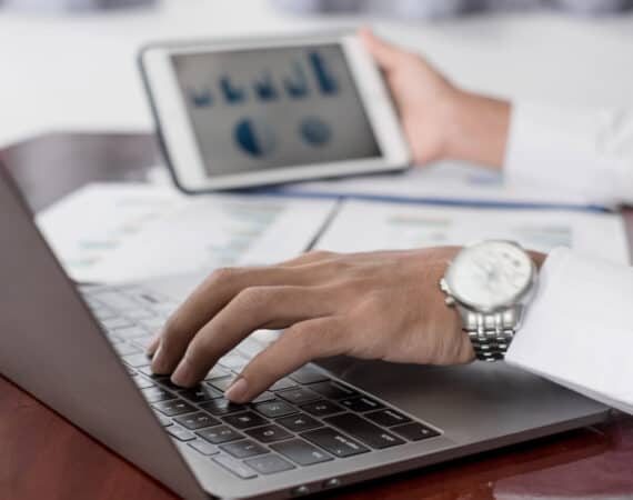 The businessman hand sits at their desks and calculates financial graphs showing the results of their investments planning the process of successful business growth.