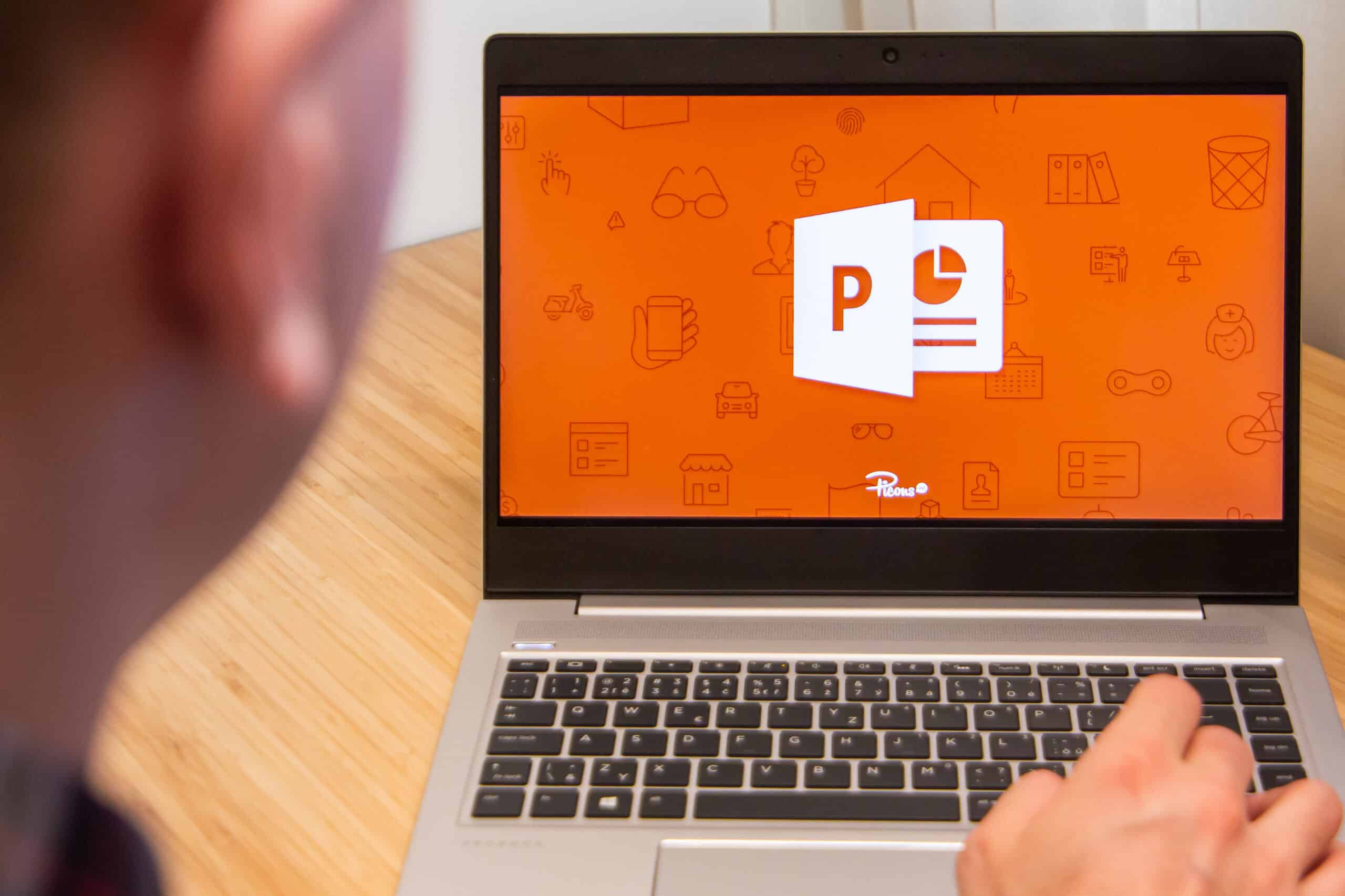 PowerPoint is used by a man on a laptop